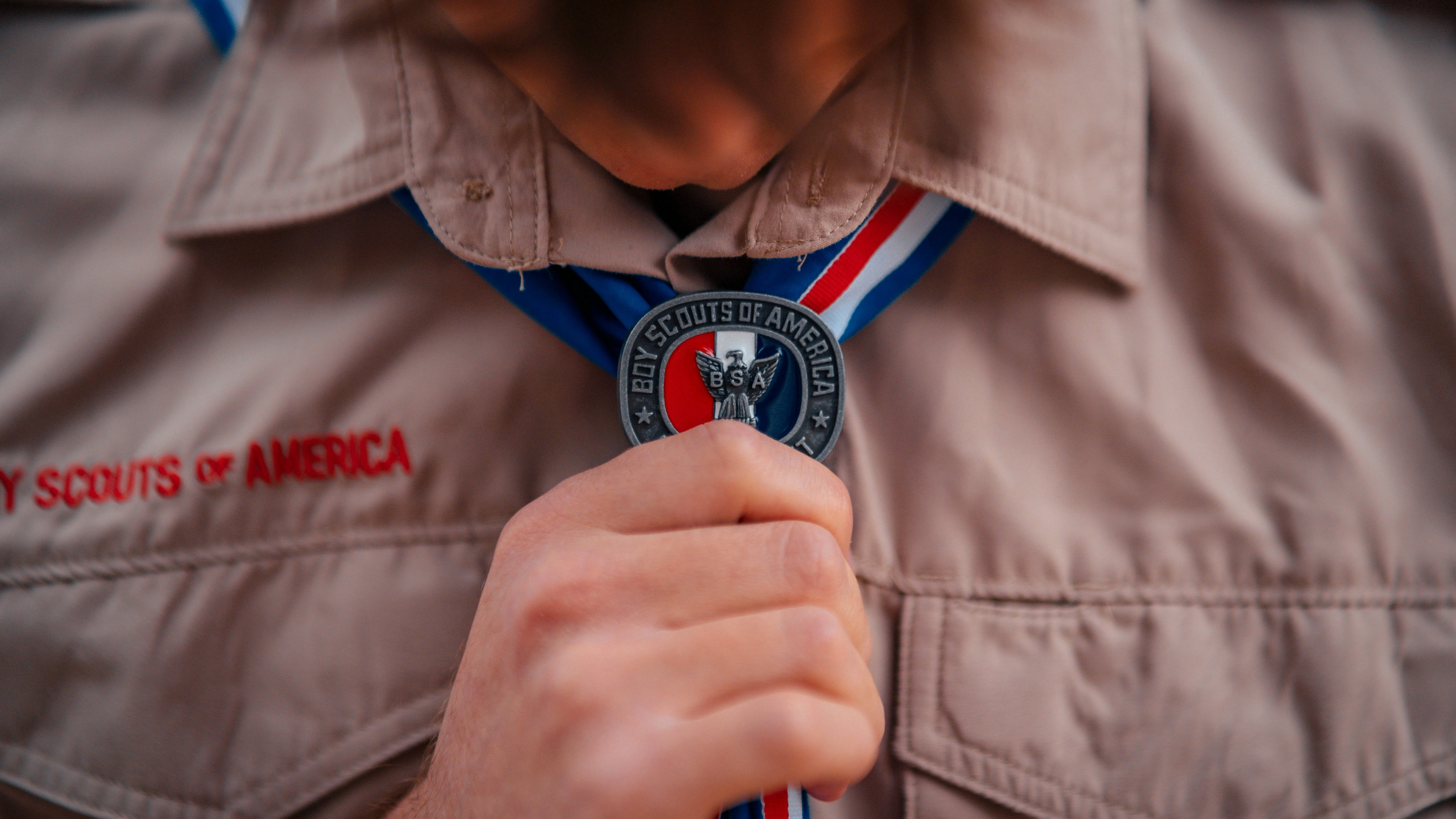 Close up of an eagle scout woggle worn by a scout as they hold it
